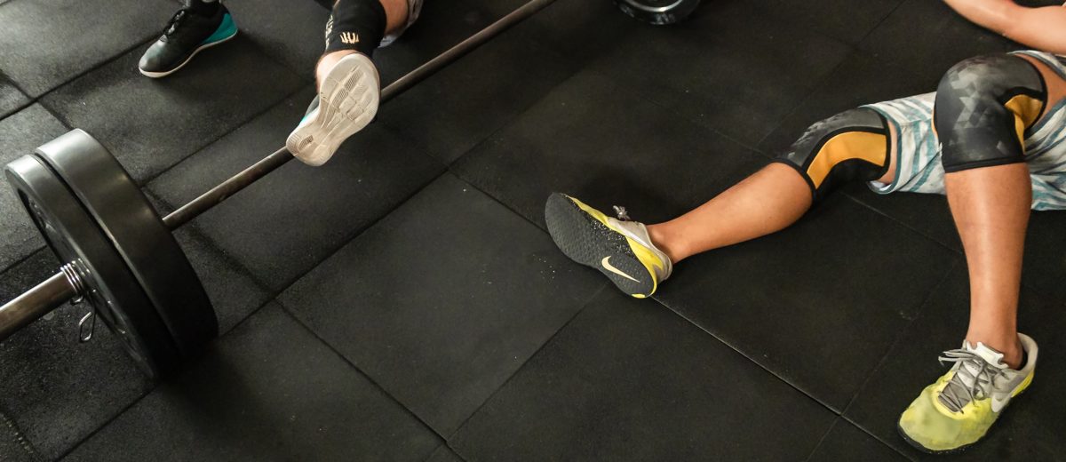 doms-two-men-lying-on-gym-floor-beside-black-barbell-2261483