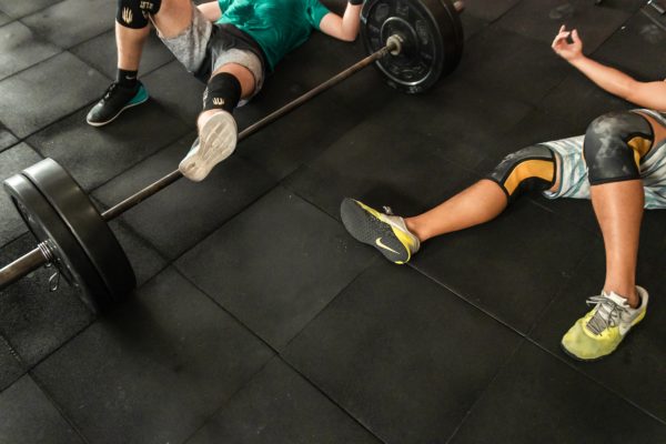 doms-two-men-lying-on-gym-floor-beside-black-barbell-2261483